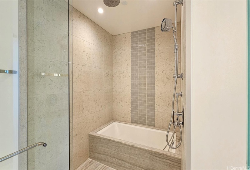 Primary Bathroom with a rain drop shower, multi function shower head, and a soaking tub