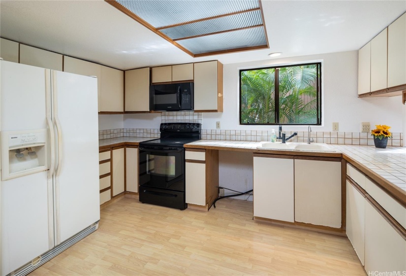 The kitchen has different flooring, a wonderful large window over the sink, and great space to work in