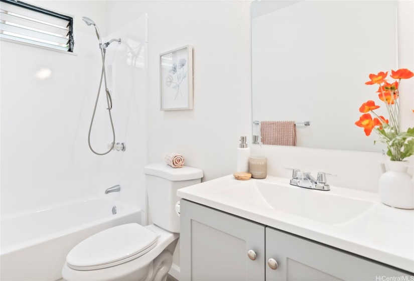 Renovated second bathroom with new toilets, sink, countertops, and reglazed shower