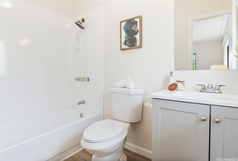 Renovated primary bathroom with new toilets, sink, countertops, and reglazed shower
