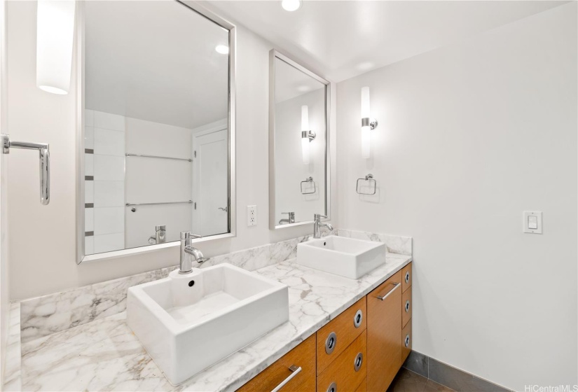 Primary bath with double sink vanity, shower & tub combination, and a walk in closet