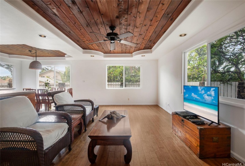 This spacious living room features a beautiful decorative wood ceiling that adds warmth and character to the space. The open layout provides plenty of room for entertaining and everyday living.