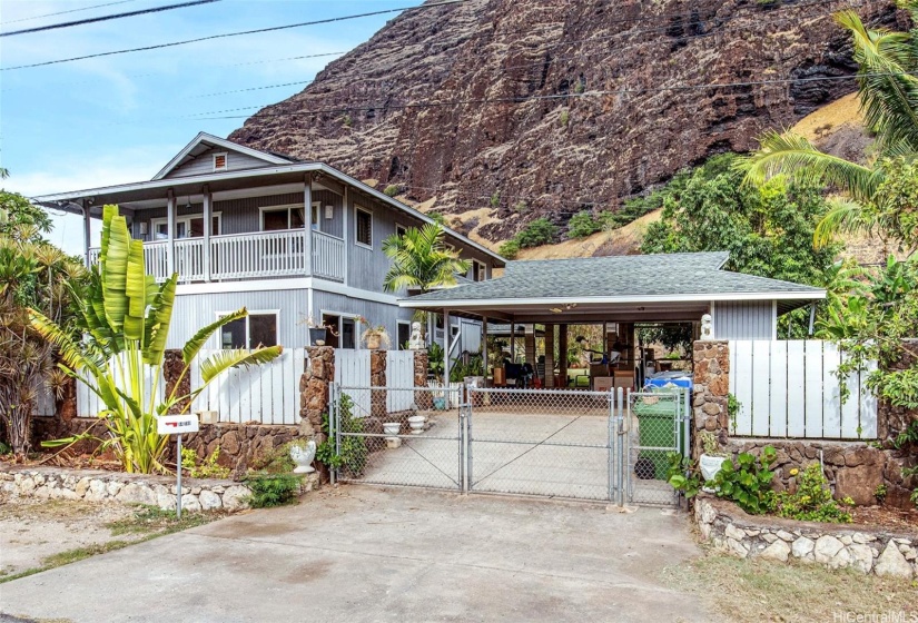 This home features a welcoming front view, complete with a fence that encloses the property. Nestled near the coastline, the house offers breathtaking mountain views with no neighbors behind, ensuring privacy and tranquility.