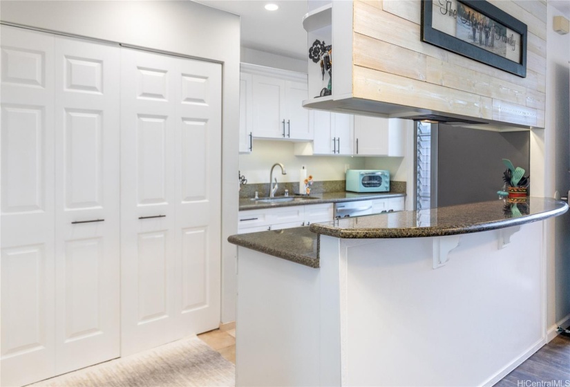 Kitchen area with closet with washer and dryer.