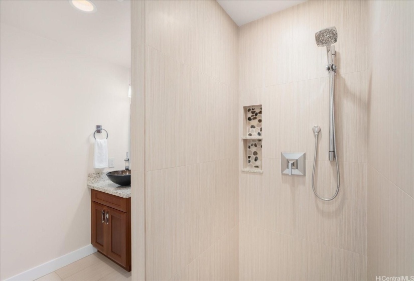 A large walk-in shower is beautifully tiled and still spotless!