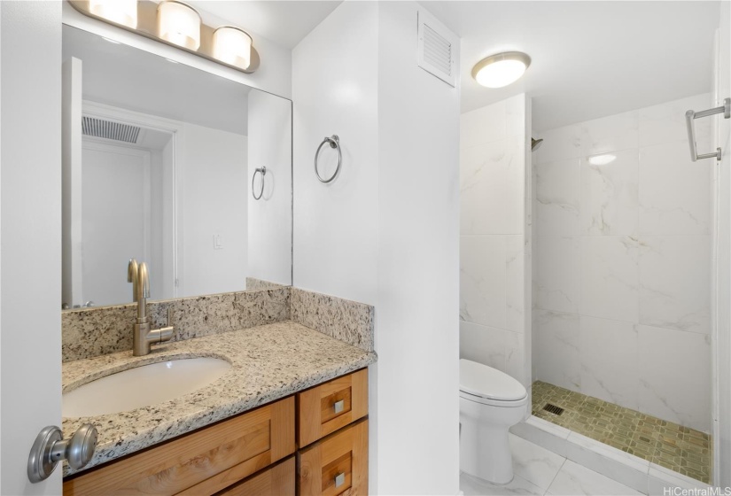 Second bath with granite vanity and tiled shower