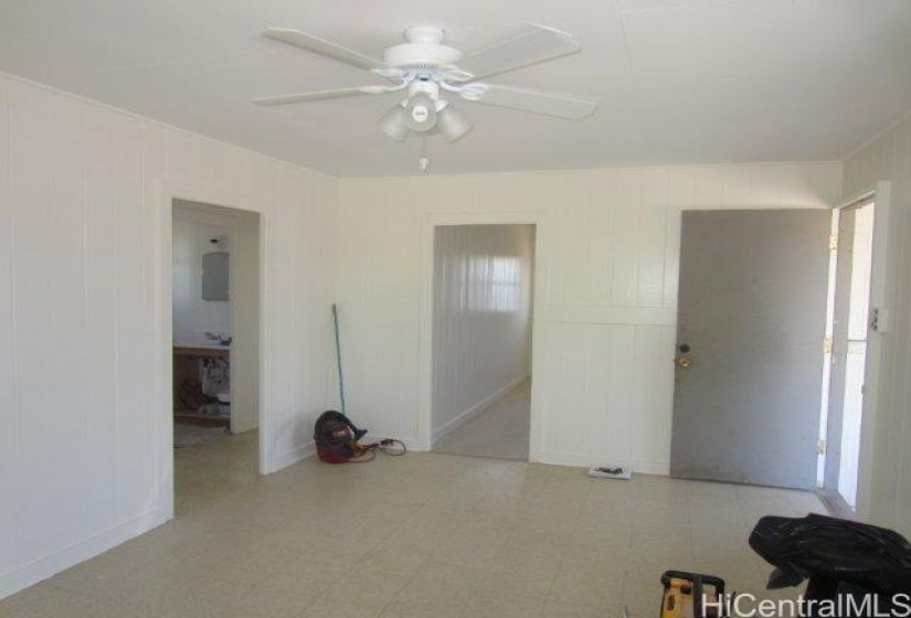 Inside the 2 bedroom cottage living room, To your right is the front door.  In the middle is the door to the large kitchen.  To the left is the hallway to the 2 bedrooms and the bathroom.