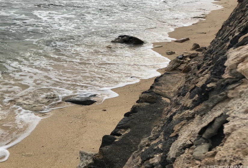 Looking straight down over the sea wall at the waves on your property.  Sandy Beach is seasonal.