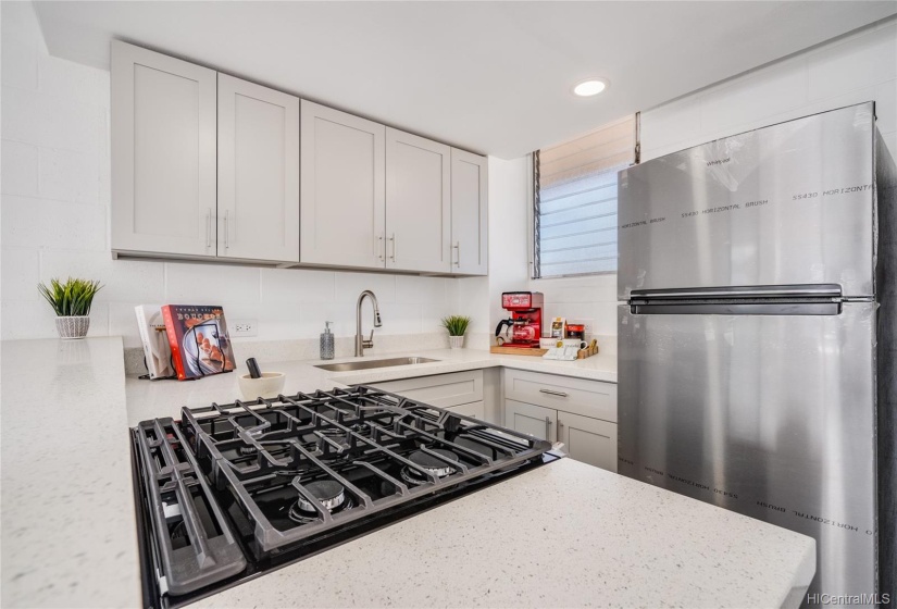 Another view of the renovated, bright kitchen with all cabinets, countertops, and new appliances including a gas range and oven for the gourmet chef!