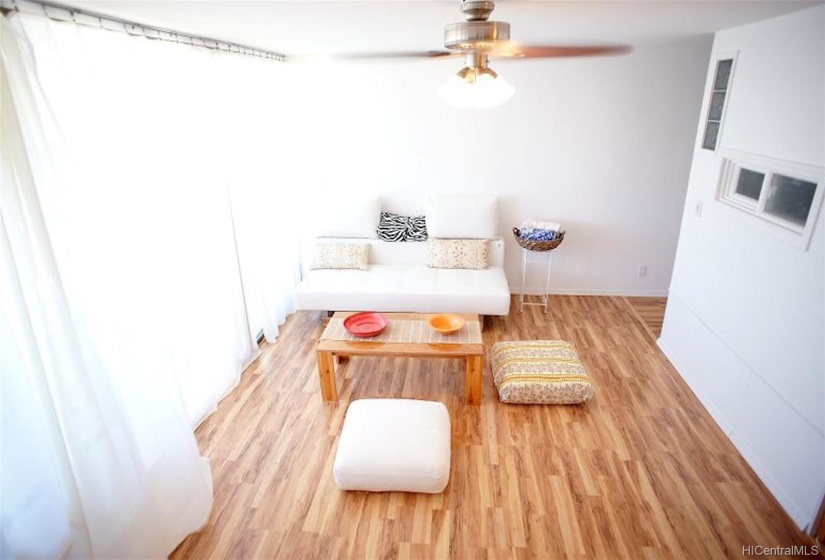 bright living room area. the unit has laminate wood plank throughout.