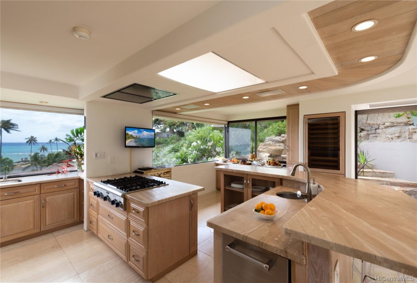 A chef's kitchen with 180-degree ocean views. Pass through window to the hot tub beyond. Perfect place to end the day.