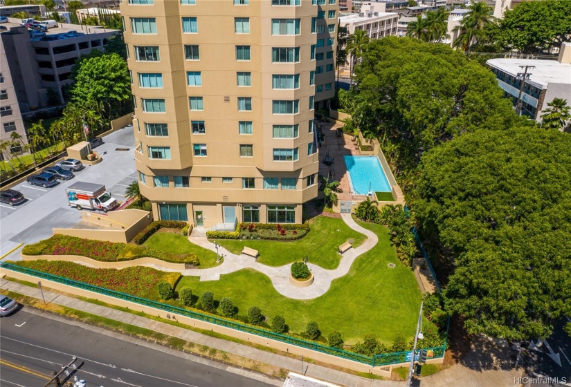 Aerial view of the pool and well kept grass area in front of building